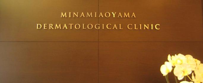 南青山皮フ科の受け付けの写真です。
正面に南青山皮フ科という意味の「MINAMIAOYAMA　DERMATOLOGICAL　CLINIC」の文字が写っています。